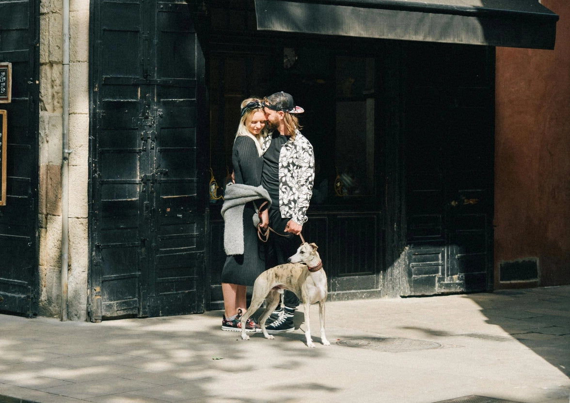 A man and a woman standing next to a dog.